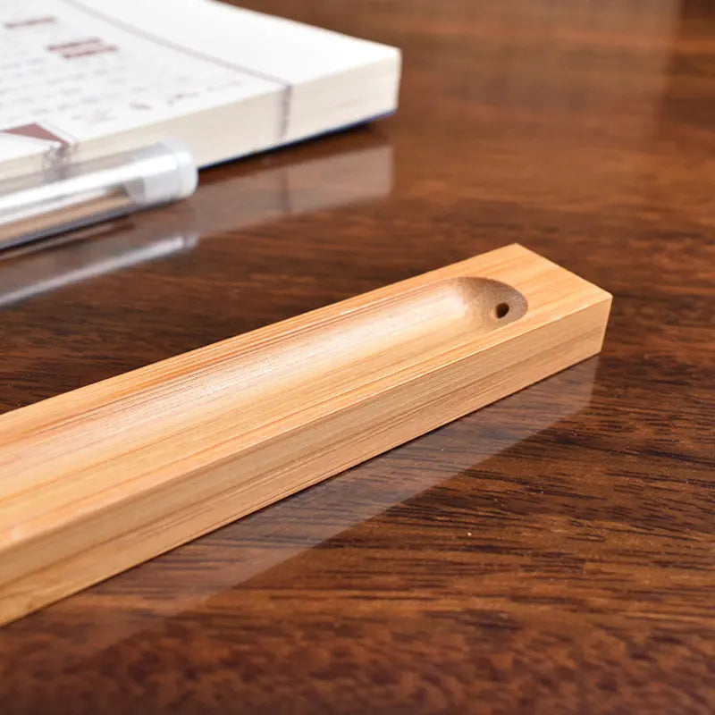 Wooden incense stick holder on a polished surface, perfect for home decor and aromatic experiences.